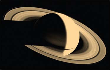 FIGURE 7.7 Saturn and its rings viewed from above and behind Saturn. The outermost A-ring, the brighter B-ring, and the fainter inner C-ring are composed of countless icy fragments with ripples and gaps due to moons orbiting nearby. SOURCE: Courtesy of NASA/JPL.