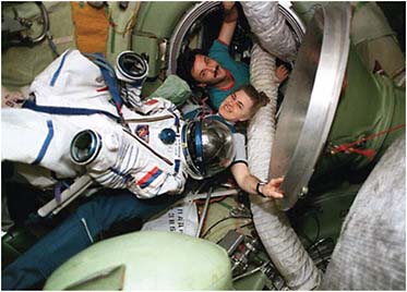 FIGURE 4.6 Shuttle-Mir: Beginning of U.S.-Russian collaboration for the long-duration spaceflight. Astronaut Shannon Lucid floats with her Russian pressure suit in the Mir space station central node. She is joined by Mir-22 flight engineer Alexander Kaleri. SOURCE: Courtesy of NASA.