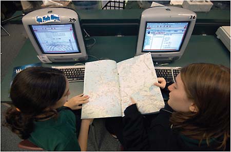 FIGURE 4.17 Seventh-graders Emily and Jessica from Westbrook Middle School in Friendswood, Texas, use a map and the Internet to determine the latitude and longitude of their next picture during the February 2006 EarthKAM session. NASA Image: JSC2006E03491. SOURCE: Courtesy of NASA Johnson Space Center. Available at http://www.nasa.gov/mission_pages/station/science/experiments/EarthKAM.html.