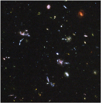 FIGURE 2.7 This enlargement of part of the Hubble Ultra Deep Field shows distant young galaxies in the process of forming; several galaxy mergers and unusual structures are evident. SOURCE: NASA, ESA, S. Beckwith, and the Hubble Ultra Deep Field team.