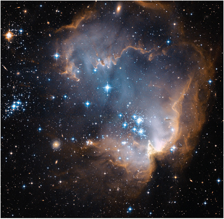 FIGURE 2.8 This Hubble image shows a young (5 million years old) cluster of massive stars eroding the dusty material around them in a region in our neighboring galaxy, the Small Magellanic Cloud. SOURCE: NASA, ESA, and the Hubble Heritage team (STScI/AURA).